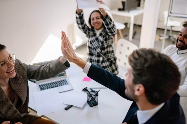 Small business team celebrating after receiving multiple new positive Google reviews.