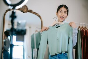 Woman filming herself while showing clothing on camera for video marketing