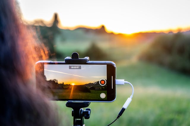 Smartphone on a tripod recording video outdoors during sunset