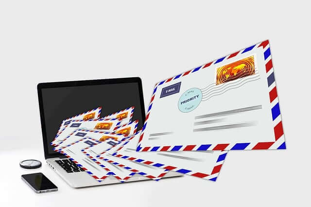Physical mail and digital emails on laptop and tablet