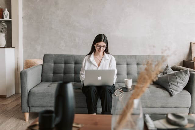 Woman working on laptop from a modern living room