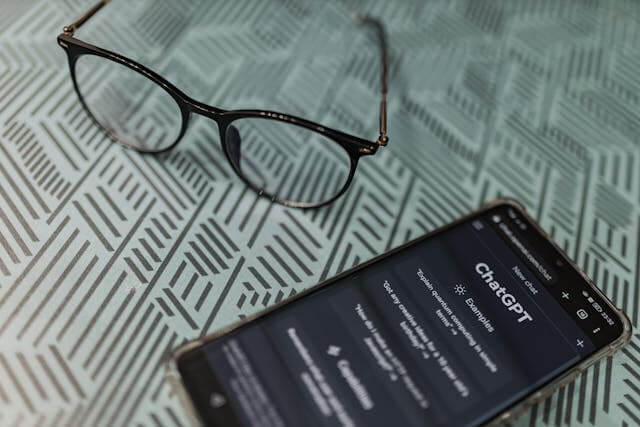 Smartphone displaying marketing analytics data next to eyeglasses on a desk