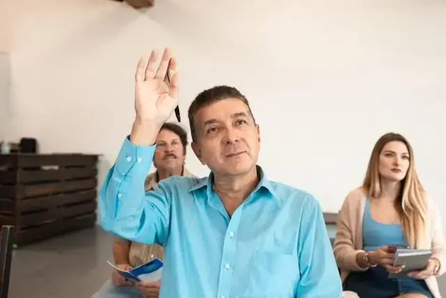 Small business customer raising his hand to ask a question